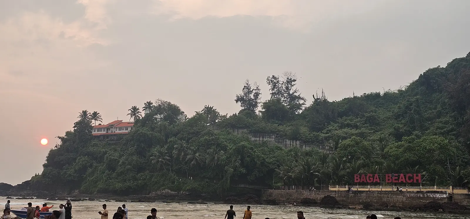 Sunset over the green headland at Baga Beach, Goa