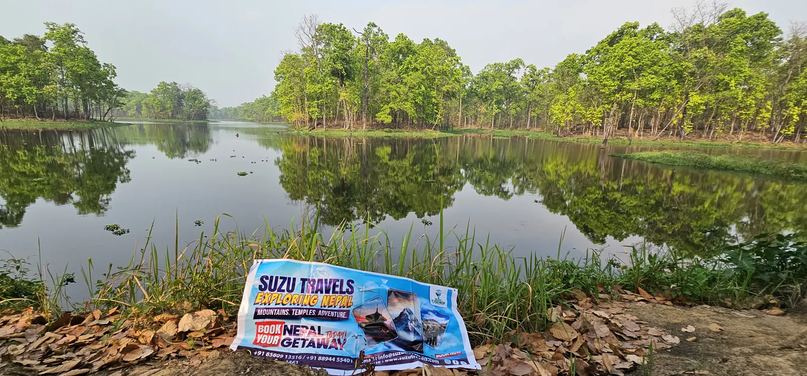 chitwan lake suzu travels Suzu Travels banner beside a lake in Chitwan, Nepal