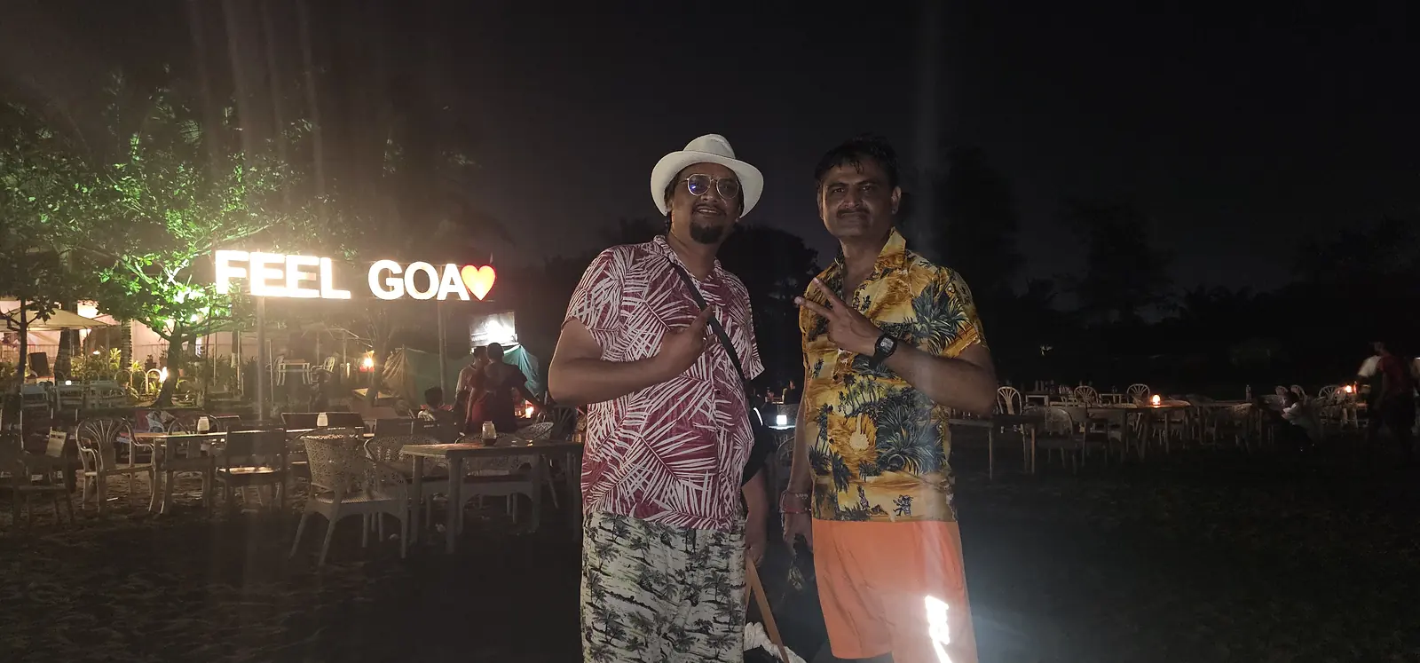 Travellers at the Feel Goa sign on a night beach