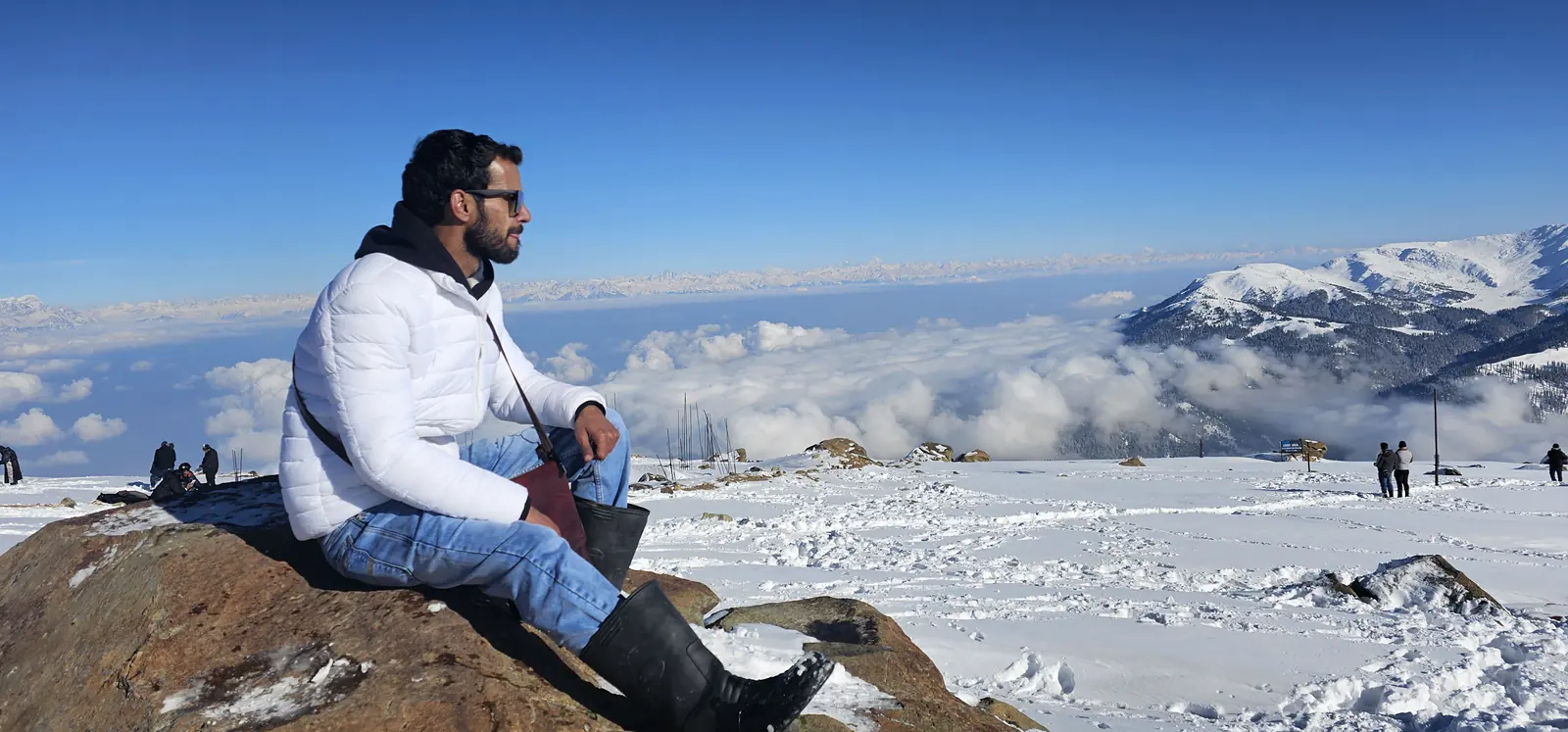 Traveller sitting above a sea of clouds at Gulmarg