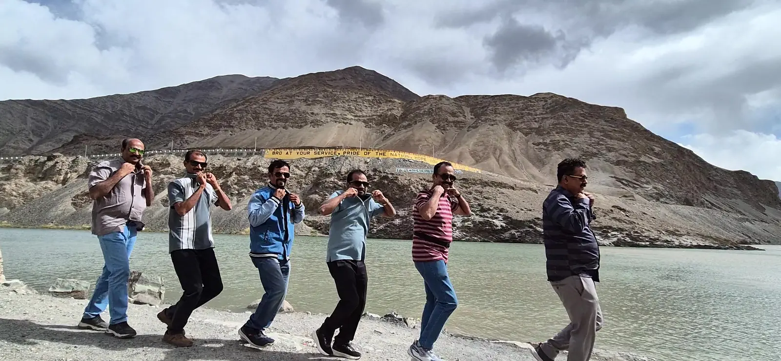 Suzu Travels group dancing by the river in Ladakh