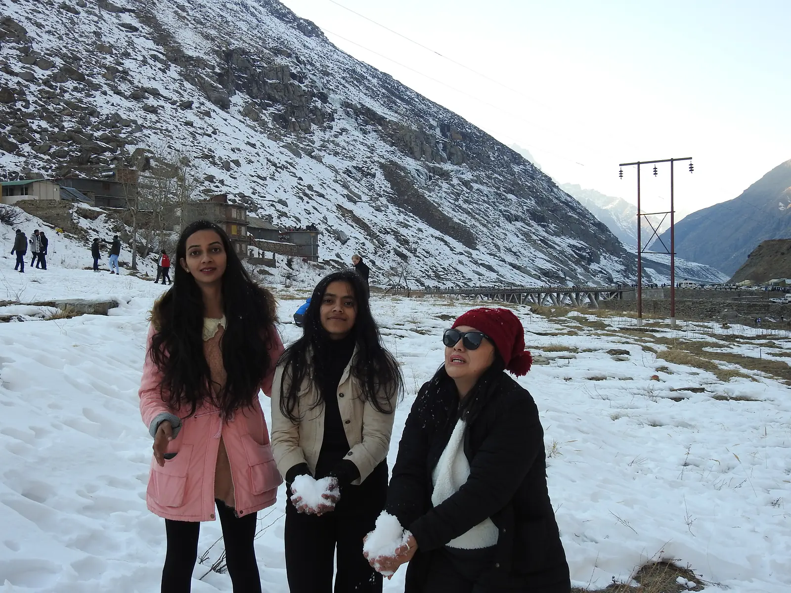 Friends posing in the snow-covered valley near Manali