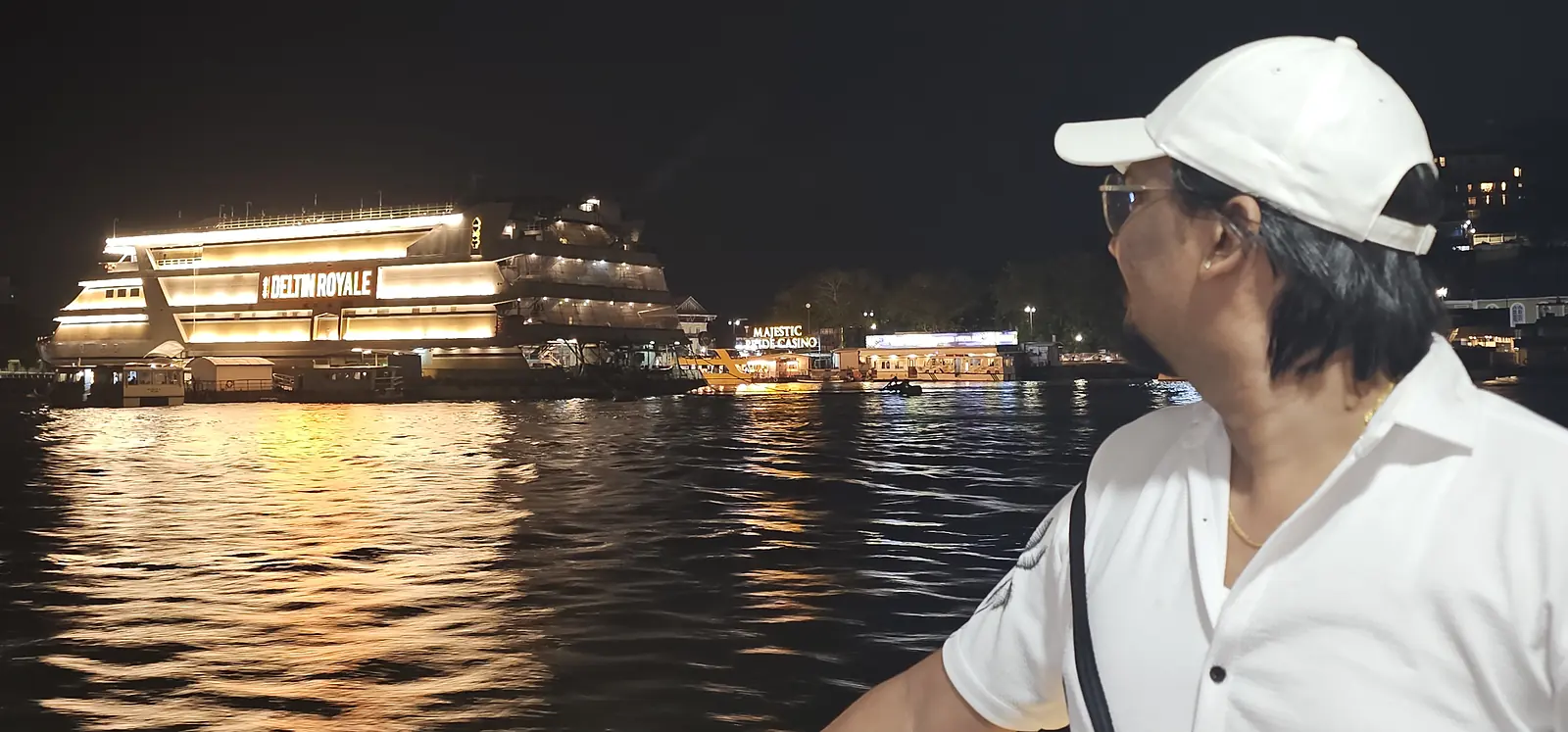 Mandovi river lit up at night with cruise boats, Goa
