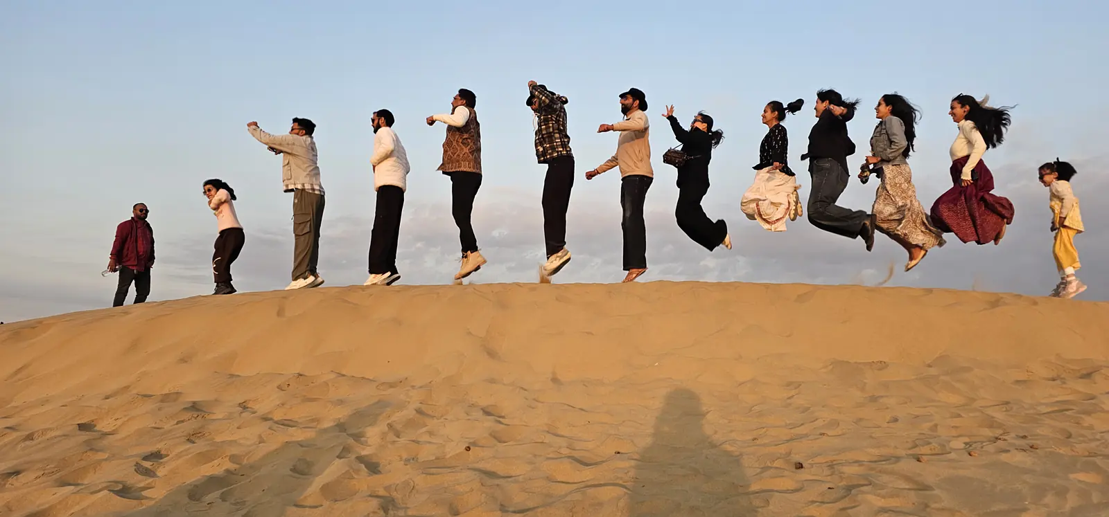 Group jumping together on the sand dunes of Jaisalmer
