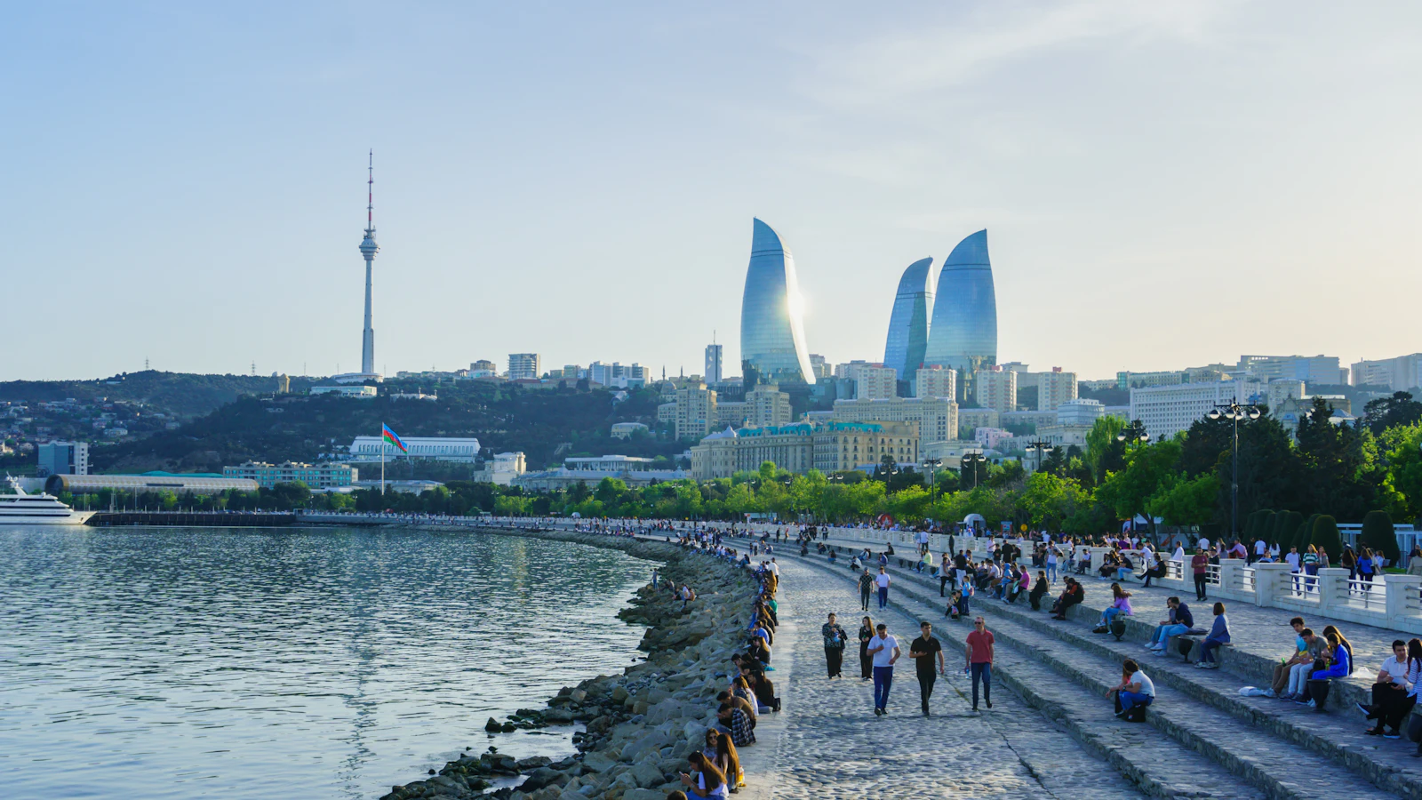 suzu abroad azerbaijan baku boulevard caspian People walking on Baku Boulevard by the Caspian Sea, with the Flame Towers in the distance, Azerbaijan