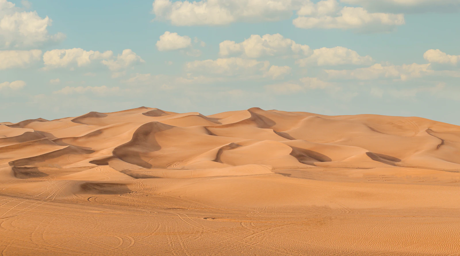 suzu abroad dubai lahbab dunes Rolling sand dunes under a blue sky in the Lahbab desert, Dubai