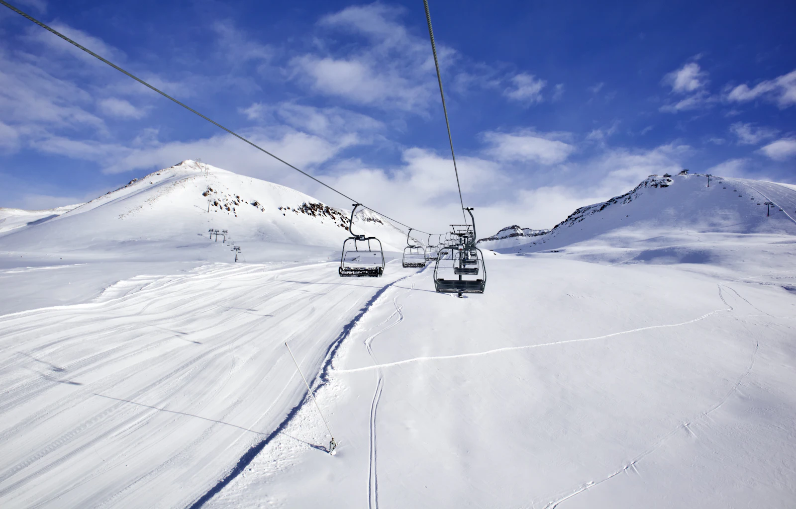 suzu abroad georgia gudauri ski lift snow Chairlift over snow-covered ski slopes under a blue sky in Gudauri, Georgia