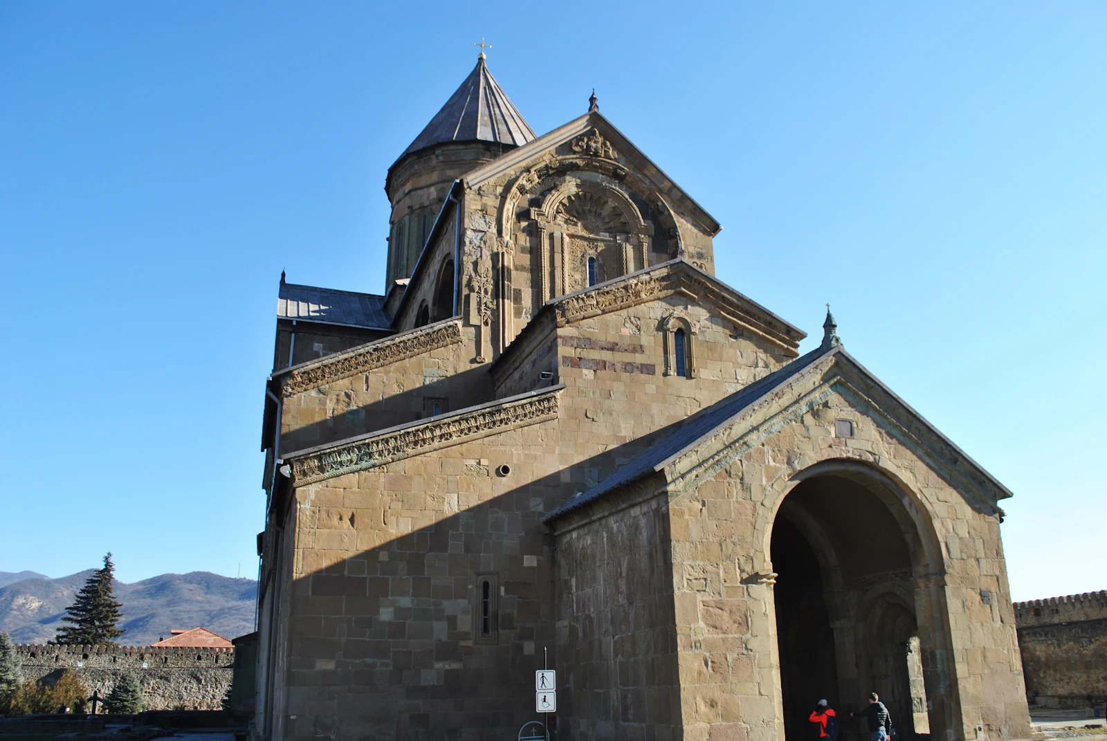 suzu abroad georgia mtskheta stone cathedral Ancient stone cathedral with a pointed dome under a clear blue sky in Mtskheta, Georgia