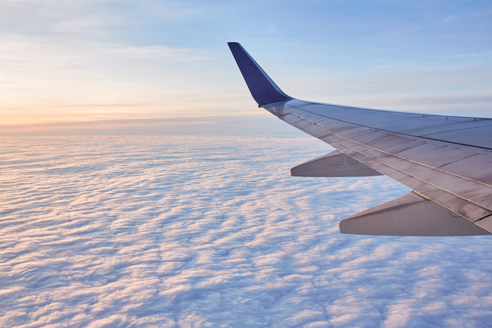 View of an aircraft wing above the clouds at sunset