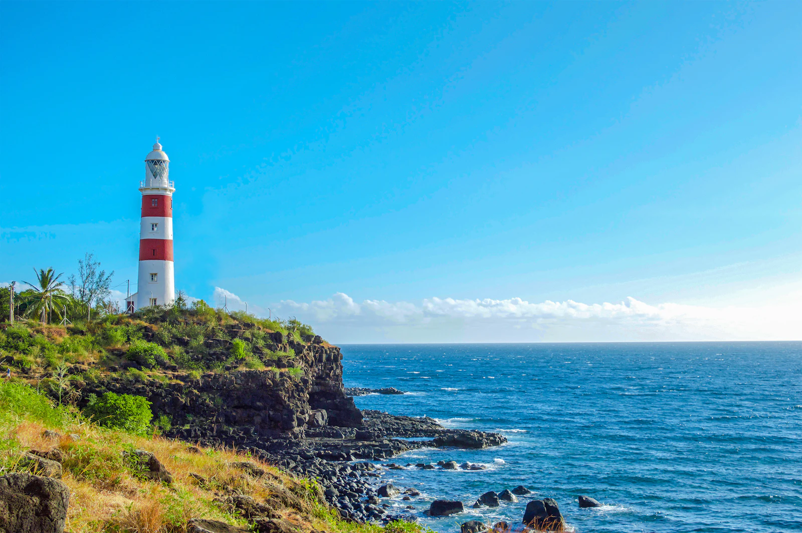 suzu abroad mauritius albion lighthouse Red-and-white Albion lighthouse on a grassy cliff above the sea, Mauritius
