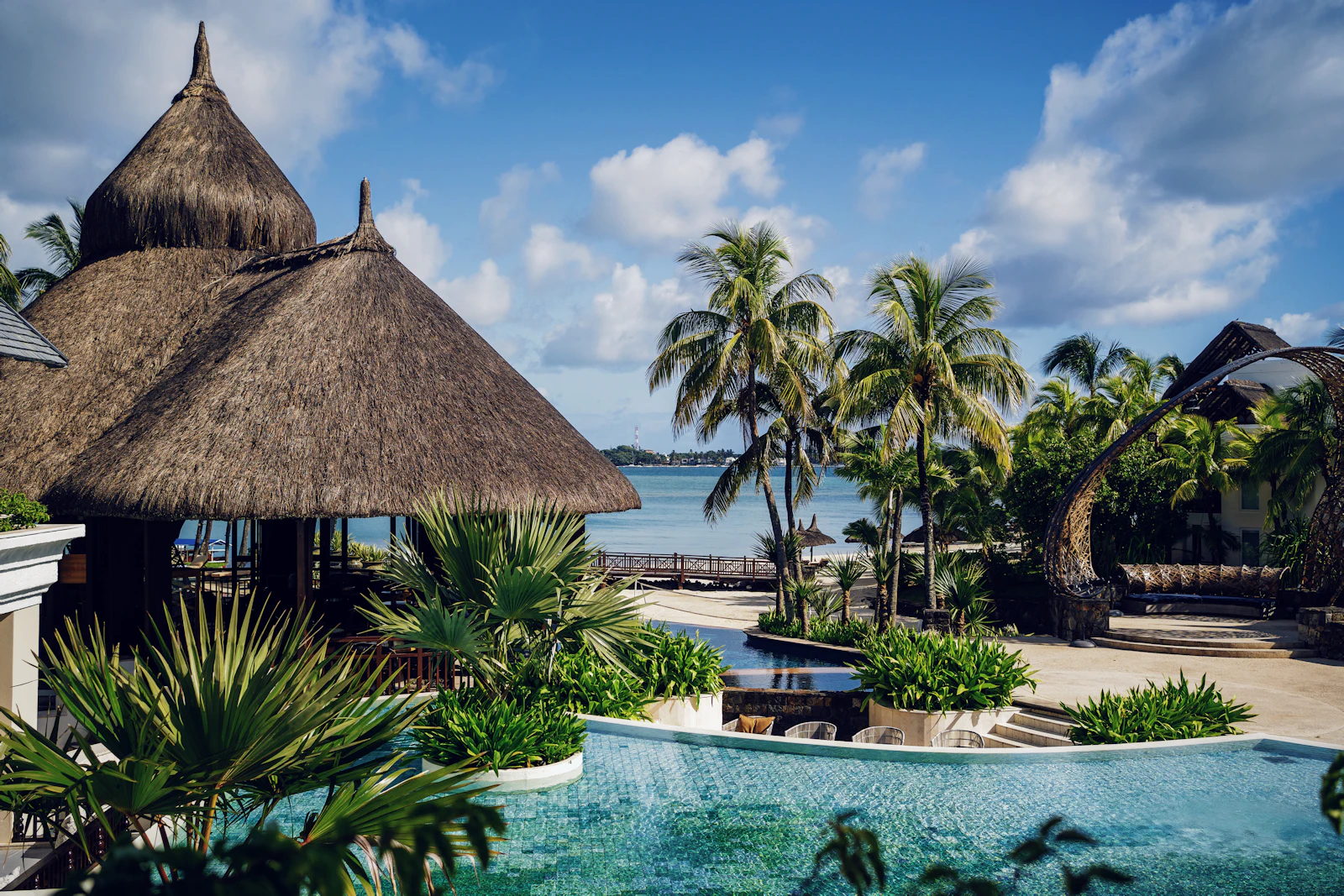 suzu abroad mauritius resort pool lagoon Thatched-roof beach resort with an infinity pool and palms beside the lagoon, Trou d'Eau Douce, Mauritius